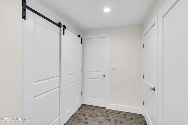 an empty room with windows and ceiling fan