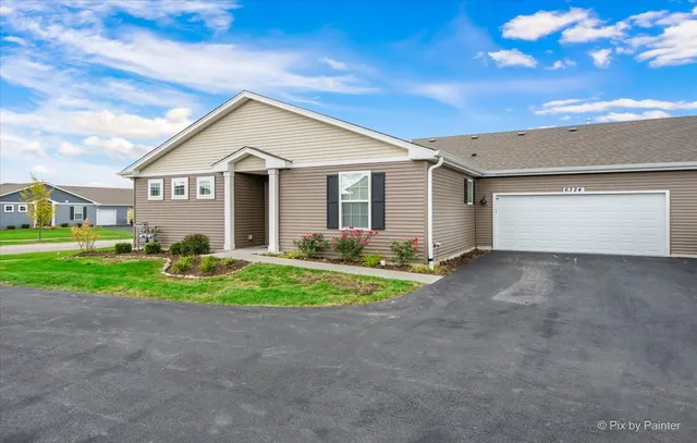 a view of a house with a yard and large tree