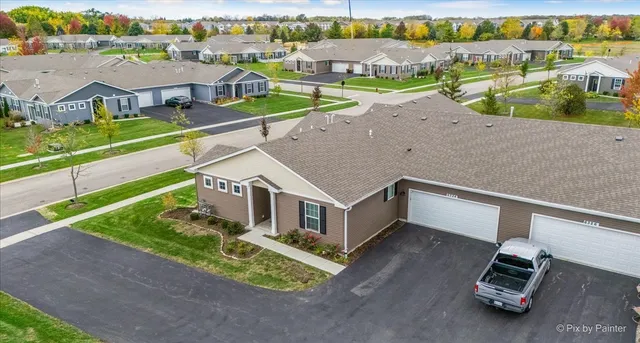 an aerial view of a house with a garden and lake view