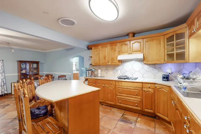 a kitchen with stainless steel appliances granite countertop a sink a stove and a refrigerator