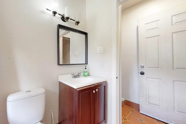 a bathroom with a toilet sink and mirror