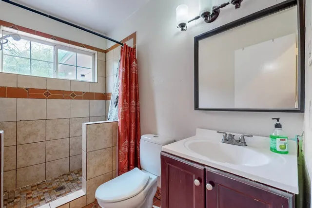 a bathroom with a sink a toilet and mirror