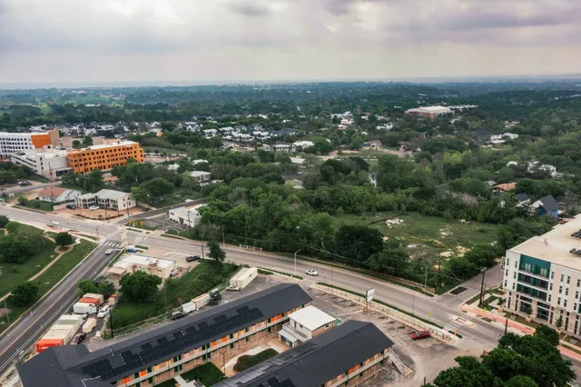 an aerial view of residential building and car parked on street side