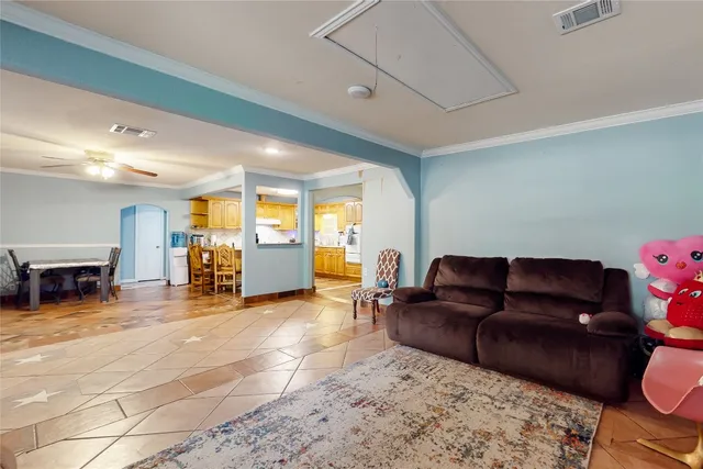 a living room with furniture and a dining table with kitchen view