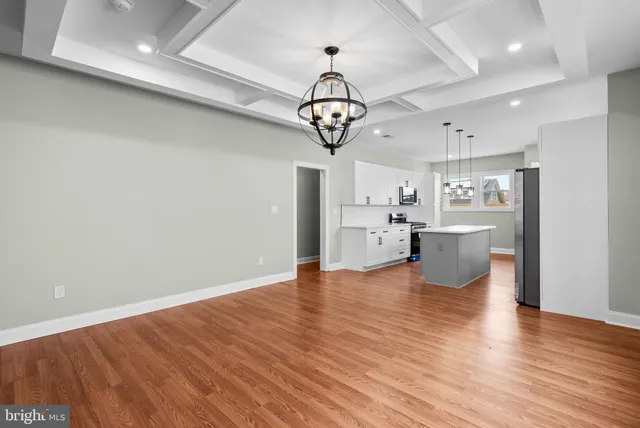 a view of a kitchen with a sink stainless steel appliances wooden floor and cabinets