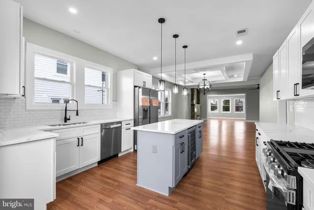 a large kitchen with stainless steel appliances granite countertop a stove oven and a sink with cabinets