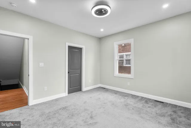 an empty room with closet and fan