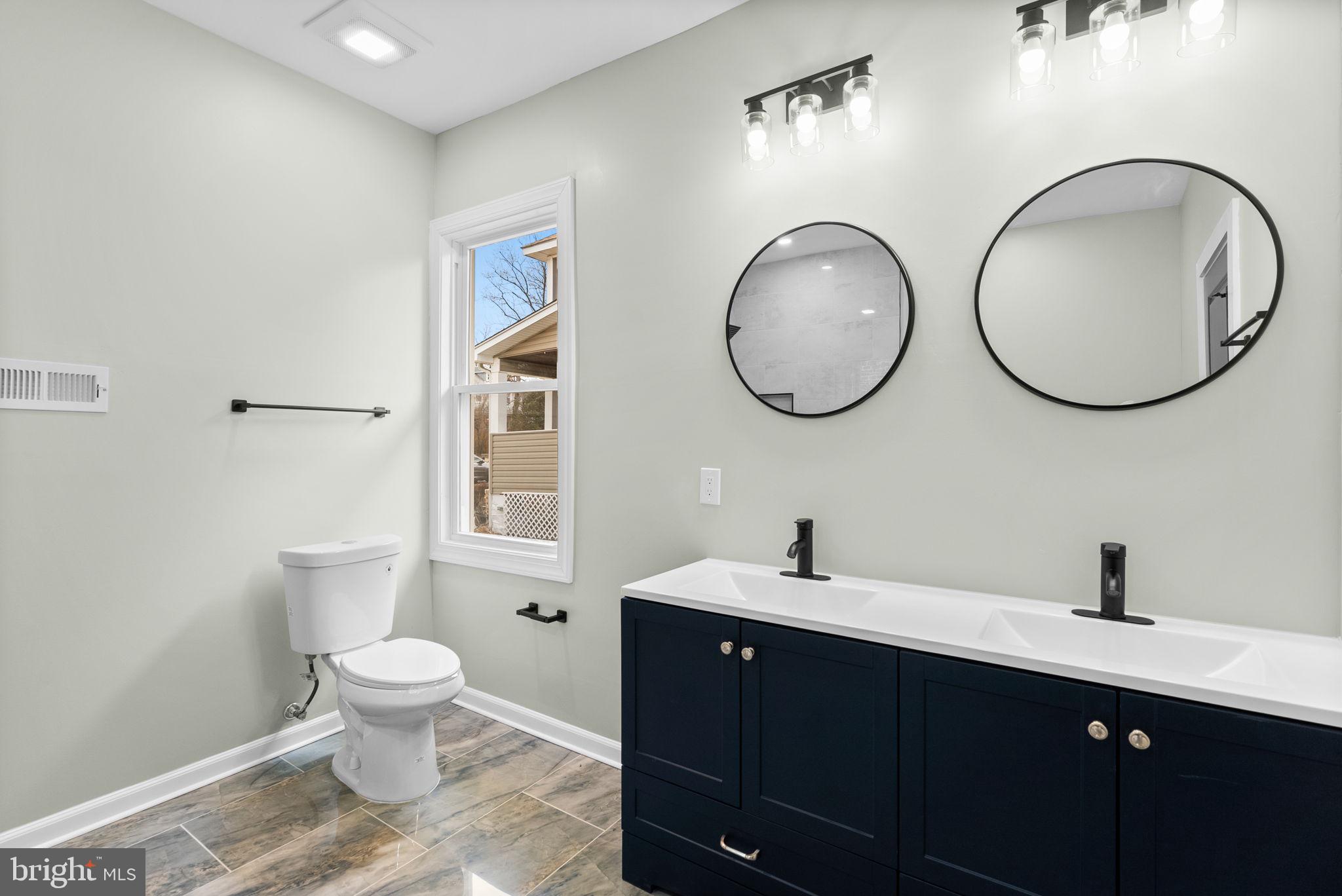 4313 Wentworth Road Baltimore, MD 21207 - Photo 25 of 46 a bathroom with a toilet a sink and a mirror