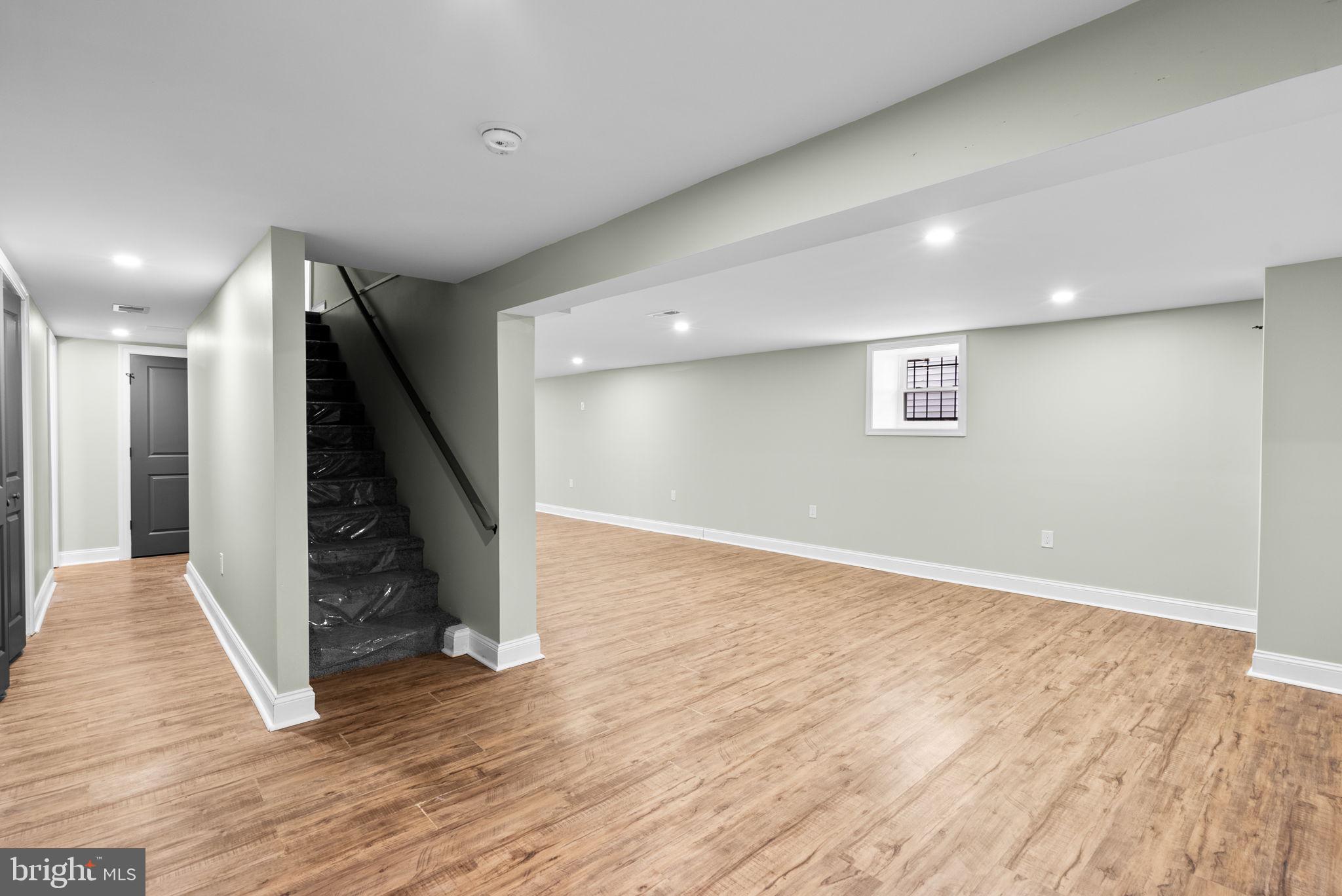 4313 Wentworth Road Baltimore, MD 21207 - Photo 36 of 46 an empty room with wooden floor and stairs
