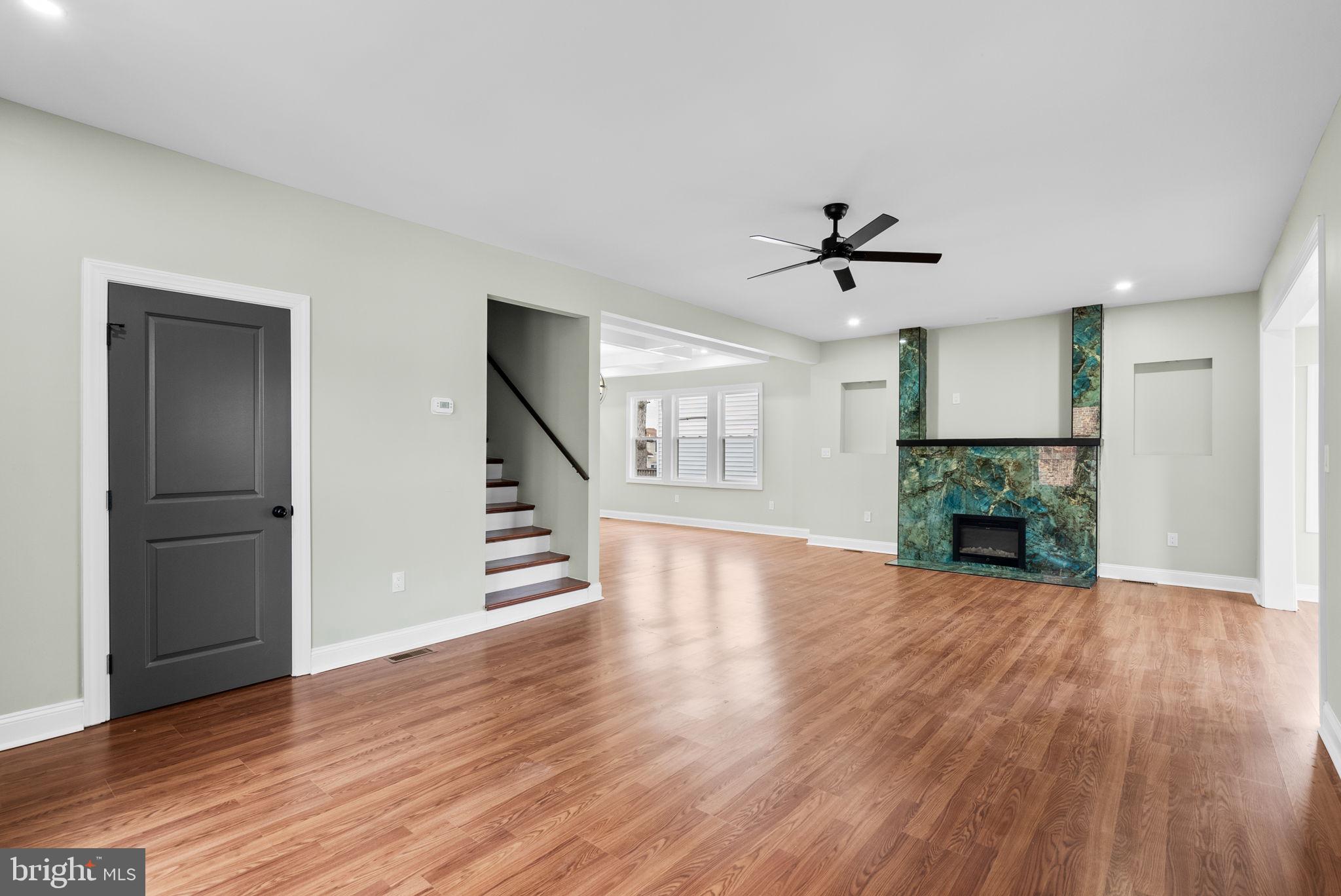 4313 Wentworth Road Baltimore, MD 21207 - Photo 4 of 46 an empty room with wooden floor a ceiling fan and windows