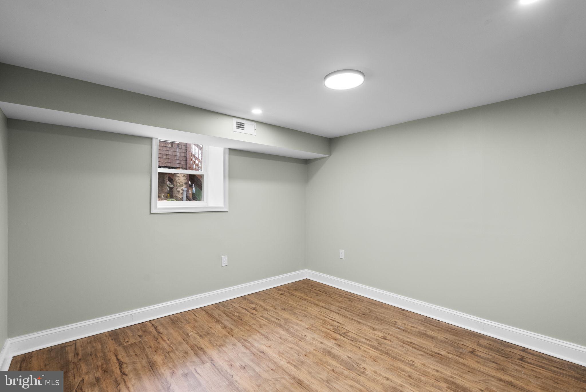 4313 Wentworth Road Baltimore, MD 21207 - Photo 41 of 46 an empty room with a wooden floor and windows