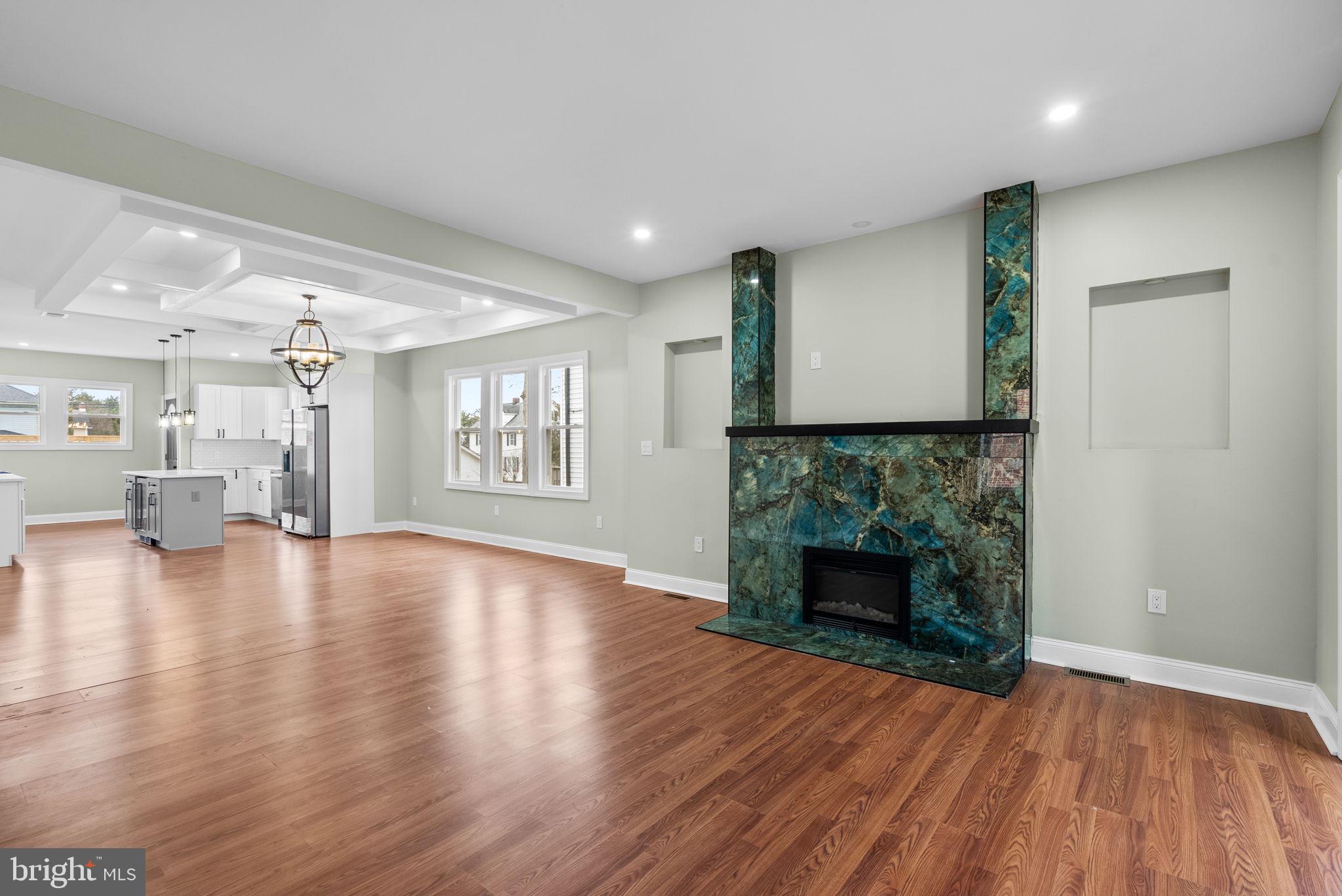 4313 Wentworth Road Baltimore, MD 21207 - Photo 7 of 46 an empty room with wooden floor fireplace and windows