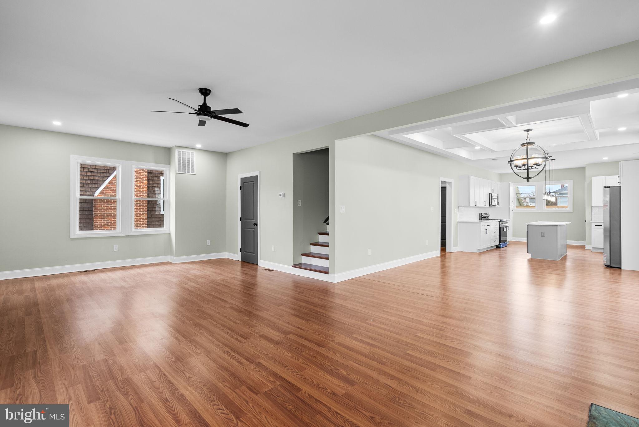 4313 Wentworth Road Baltimore, MD 21207 - Photo 9 of 46 a view of an empty room with wooden floor and a kitchen
