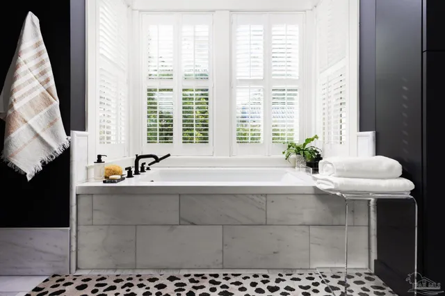 a bath tub sitting in a bathroom next to a window