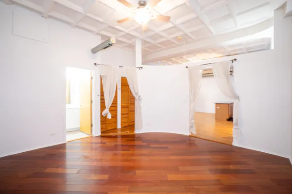a view of an empty room with wooden floor