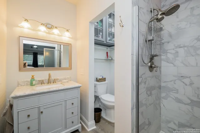 a bathroom with a double vanity sink mirror and toilet