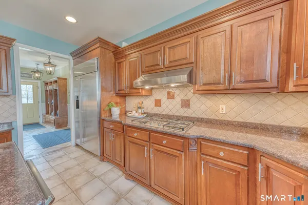 a kitchen with stainless steel appliances granite countertop a sink and a refrigerator
