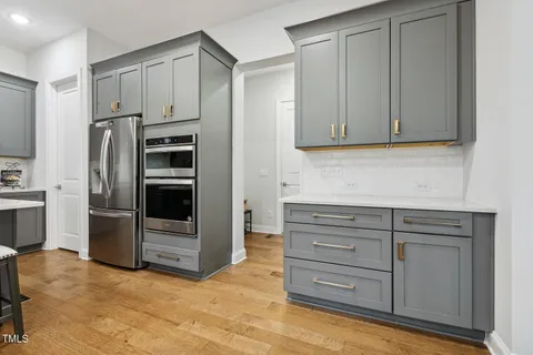 a living room with furniture kitchen view and a large window
