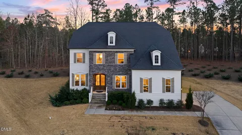 a aerial view of a house with swimming pool lawn chairs and a yard