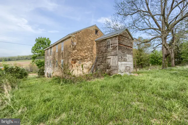 a brick building with green field in front of it