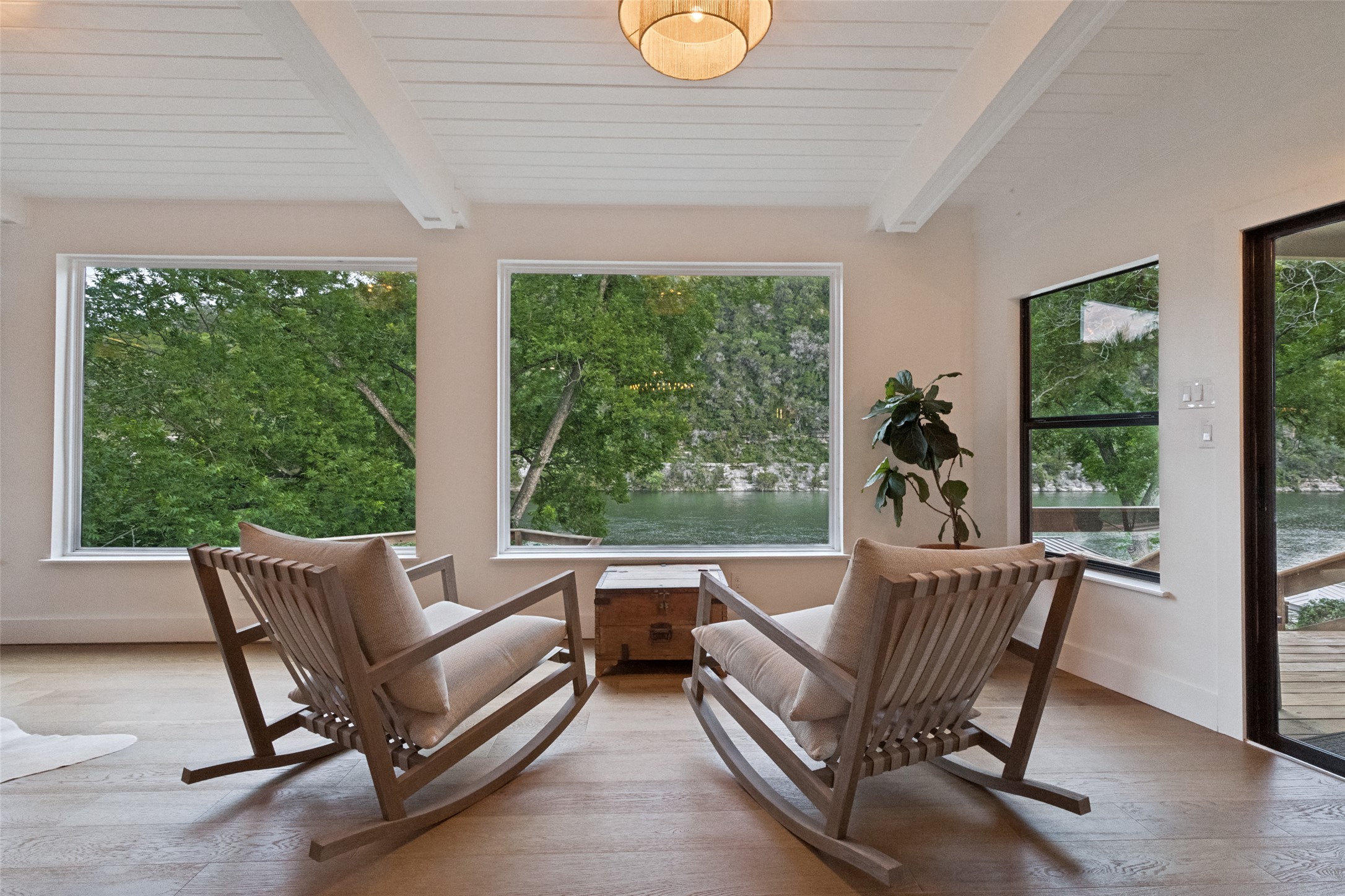 303 Lago Verde Road Austin, TX 78734 - Photo 16 of 39 A tranquil interior space overlooking a scenic body of water and lush natural surroundings.