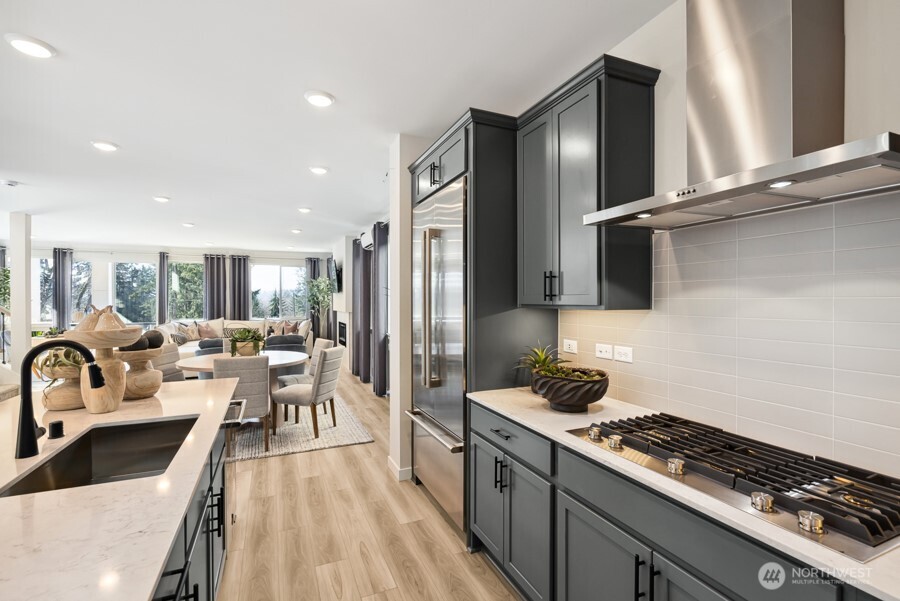 4249 Aberdeen Way Northeast Renton, WA 98056 - Photo 16 of 38 a kitchen with stainless steel appliances a sink a stove a refrigerator cabinets and living room view