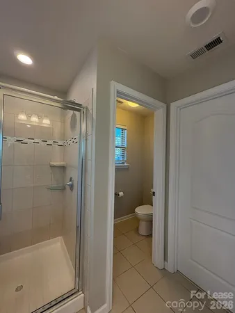 a bathroom with a granite countertop toilet a sink and shower