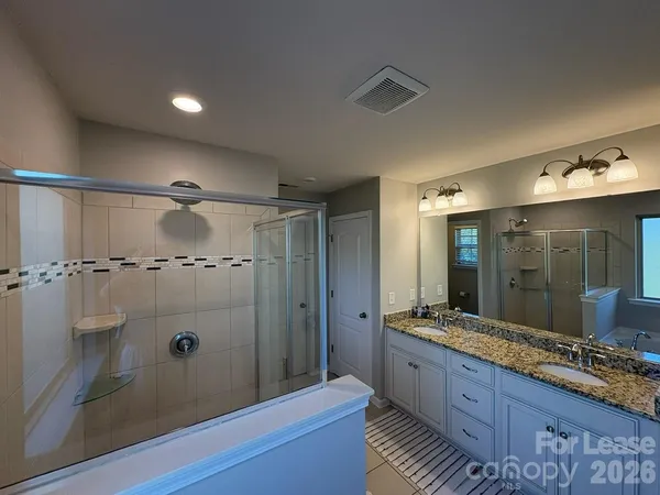 a bathroom with double vanity and a shower