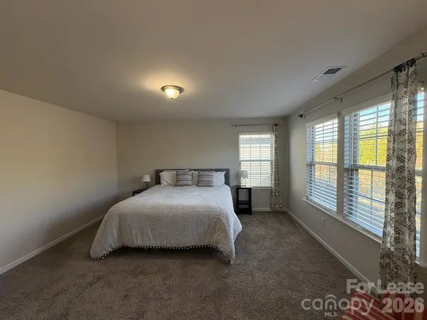 a bedroom with a bed and a large window