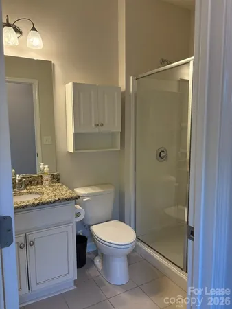 a bathroom with a granite countertop sink toilet a mirror and shower