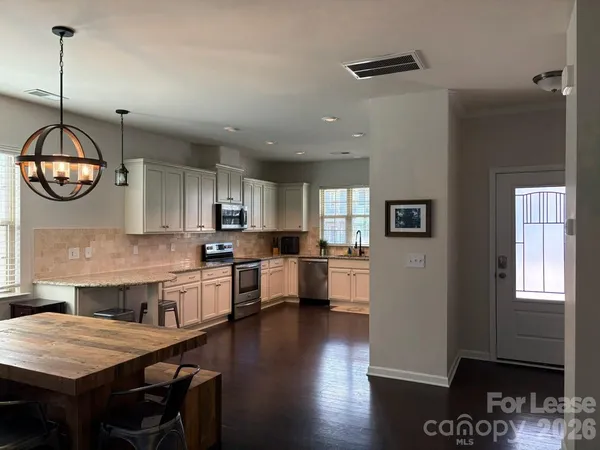 a large kitchen with lots of counter space a sink appliances and dining table
