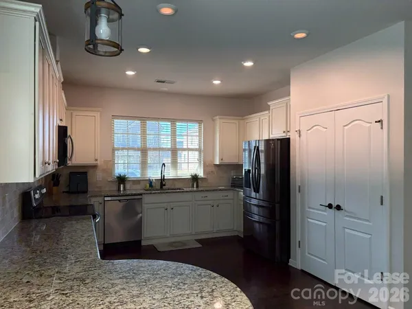 a kitchen with stainless steel appliances a refrigerator a sink a stove and cabinets