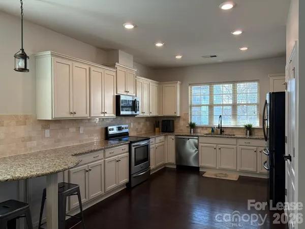 a kitchen with appliances a sink and cabinets