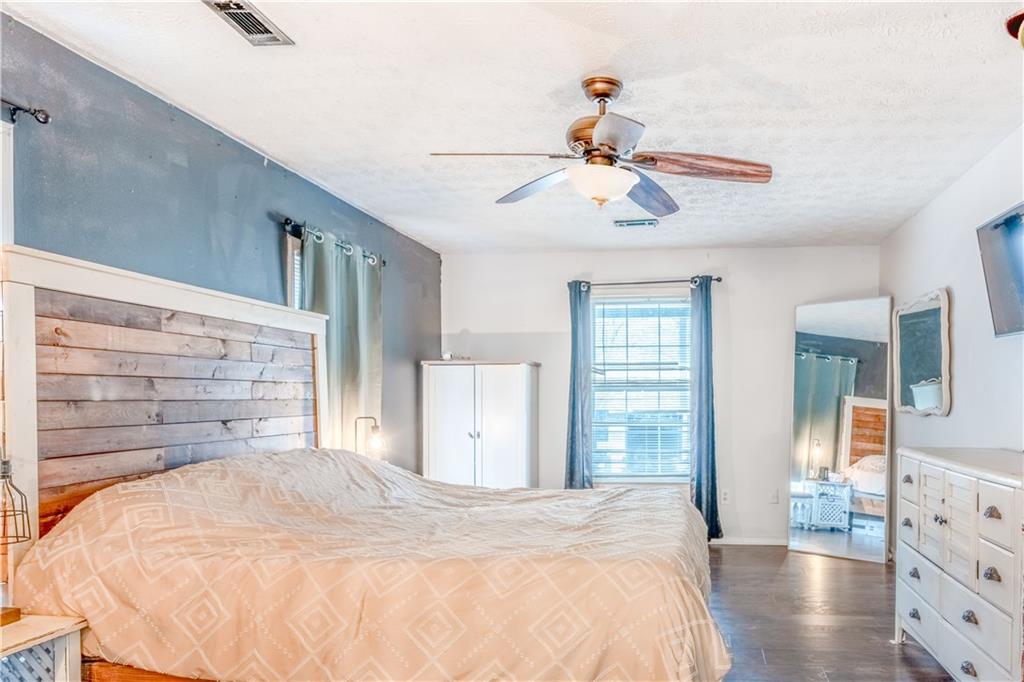 1280 Ragan Road Douglasville, GA 30134 - Photo 17 of 33 a bedroom with a bed a dresser and a chandelier