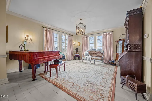 a bedroom with a bed table chair and a chandelier