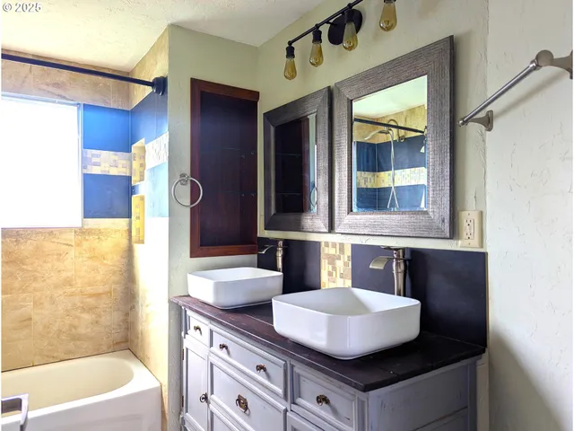 a bathroom with a tub sink and mirror