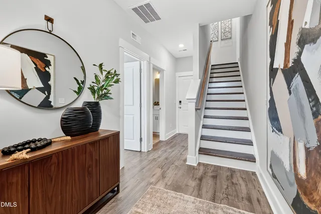 a view of a hallway with wooden floor and staircase