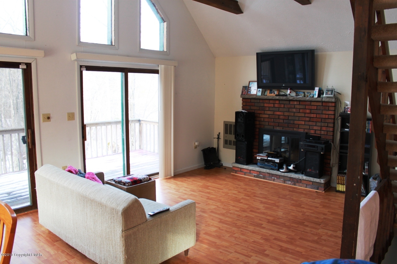 1449 Clover Road Long Pond, PA 18334 - Photo 6 of 29 a living room with furniture a flat screen tv and a fireplace