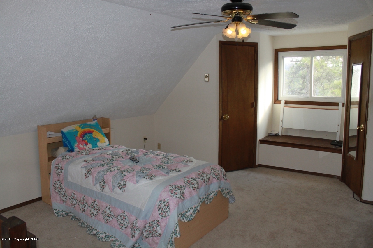 1449 Clover Road Long Pond, PA 18334 - Photo 7 of 29 a bedroom with a bed and a chandelier