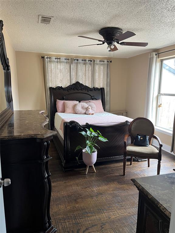 3610 Bertrand Avenue Dallas, TX 75210 - Photo 6 of 10 a bedroom with a bed and a chandelier