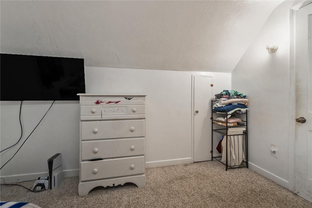 331 East Lizard Creek Road Lehighton, PA 18235 - Photo 32 of 37 A cozy bedroom with sloped ceilings features neutral carpeting and a wall-mounted light fixture.