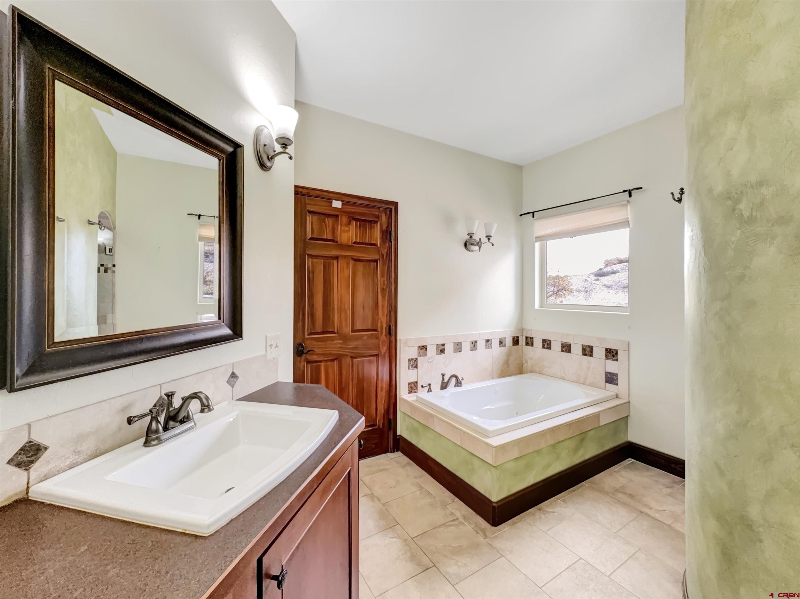 1794 Roubideau Street Delta, CO 81416 - Photo 17 of 35 a bathroom with a tub sink and mirror