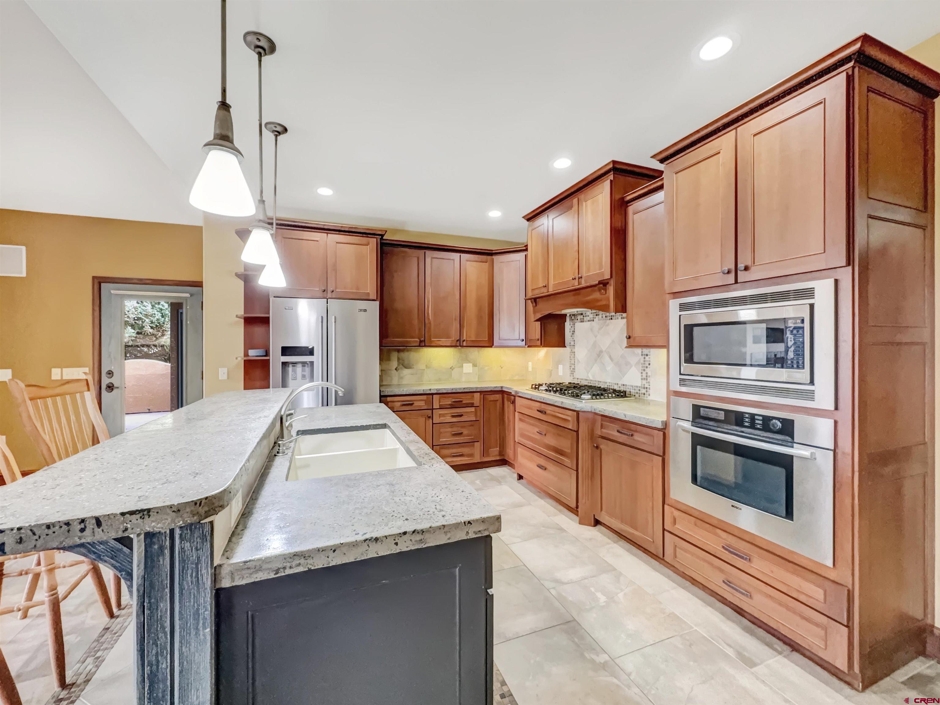 1794 Roubideau Street Delta, CO 81416 - Photo 4 of 35 a kitchen with stainless steel appliances granite countertop a kitchen island hardwood floor sink stove dining table and chairs