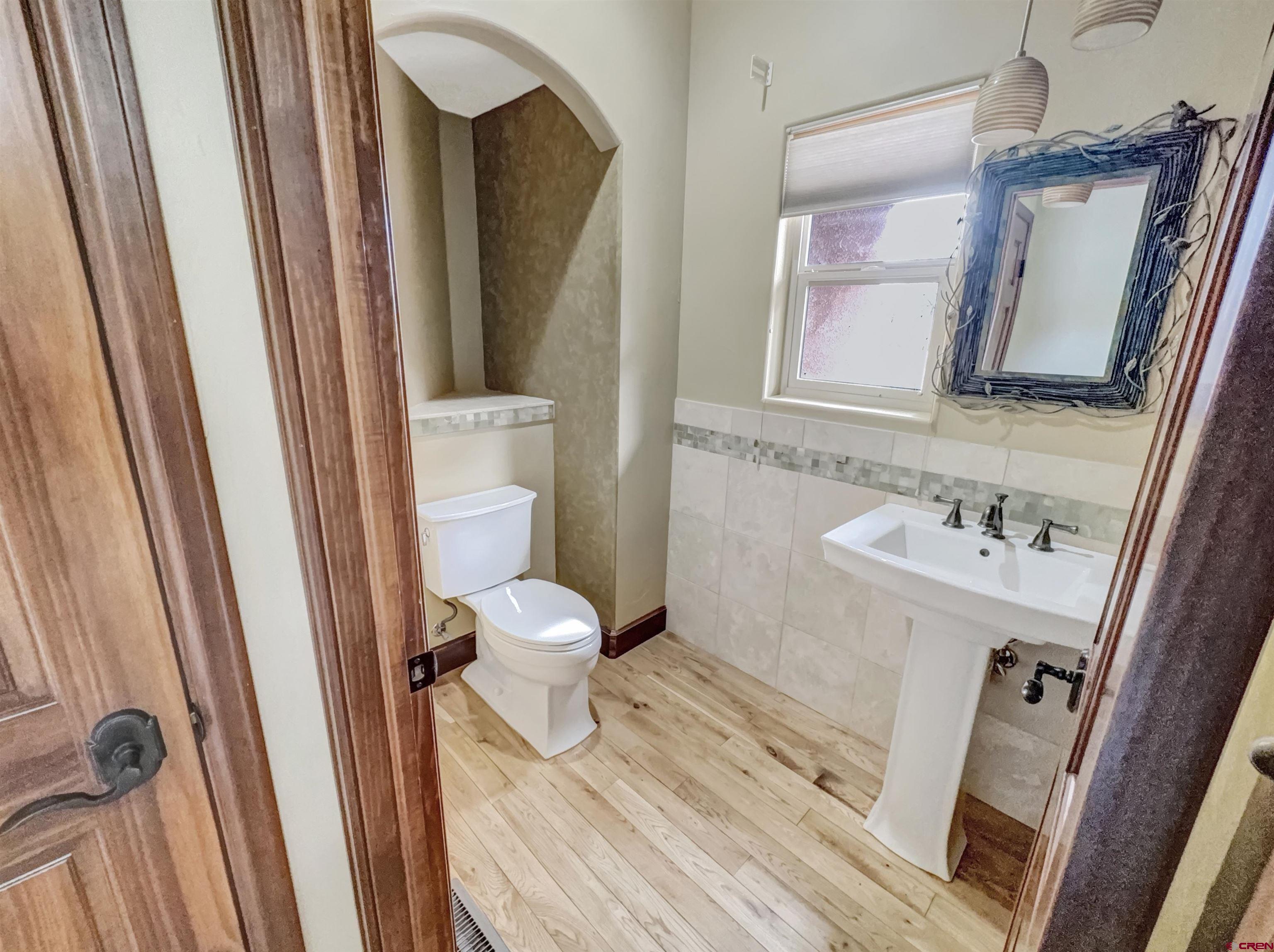 1794 Roubideau Street Delta, CO 81416 - Photo 10 of 35 a bathroom with a sink a toilet a mirror and vanity