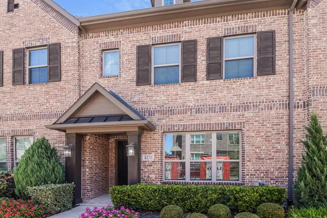 a front view of a house with a lots of windows and plants