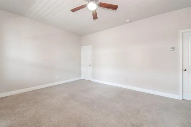 an empty room with chandelier fan