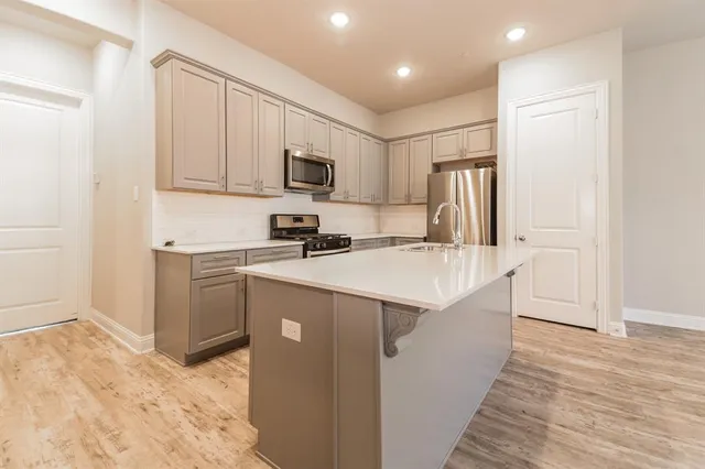 a view of a kitchen with a sink and a refrigerator