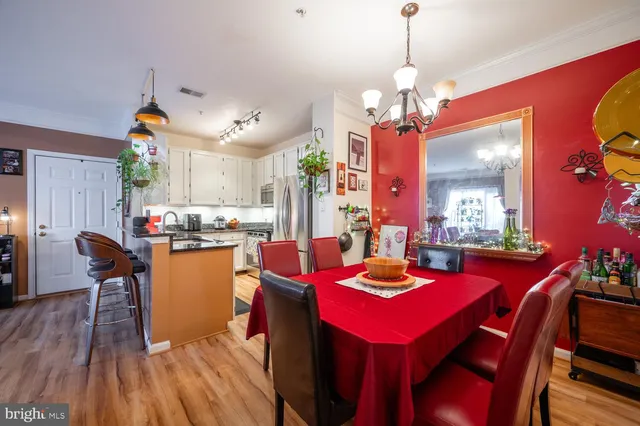 a dining room with wooden floor and chandelier