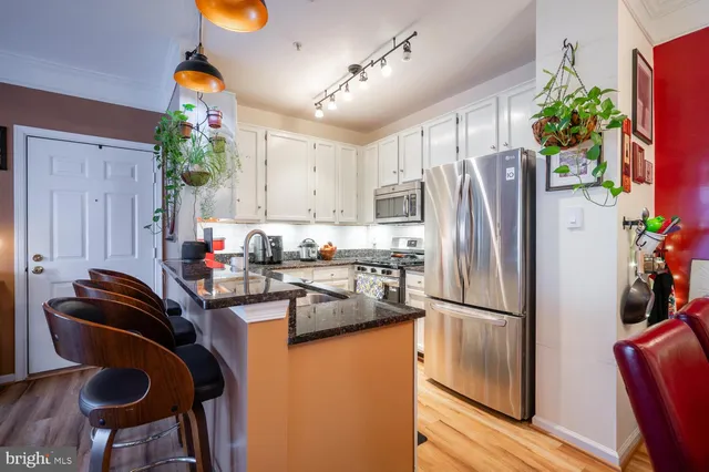a kitchen with stainless steel appliances granite countertop a refrigerator and a stove