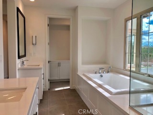 67 Tundra Irvine, CA 92602 - Photo 26 of 30 a bathroom with a tub a sink a mirror and a shower